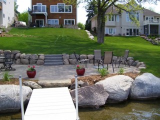Lakeside paver patio with boulder walls and mulch